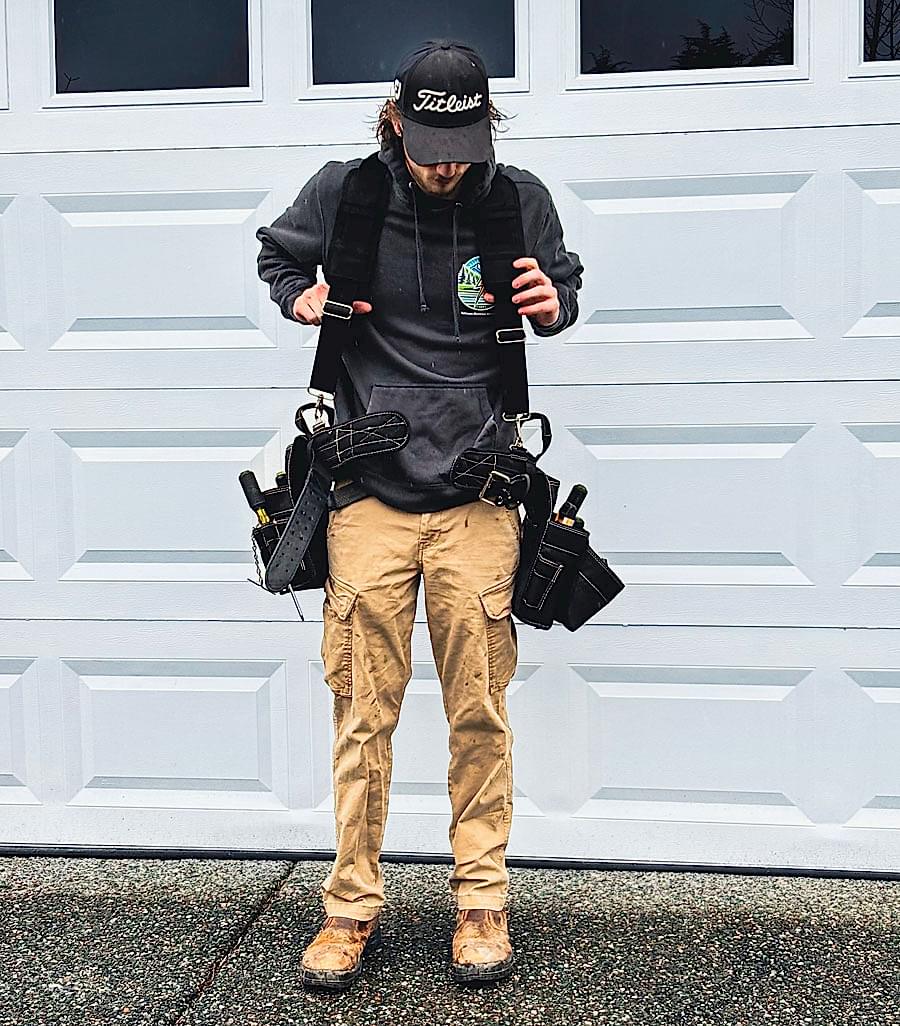 electrical-service-man-01 Electrician with professional tool belt standing outside a home in Mount Vernon, WA, representing Johnson Electrical Services.