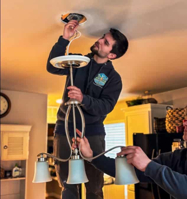 electrician-snohomish-wa Electrician installing a modern light fixture in a home in Snohomish, WA, providing professional residential electrical services and lighting upgrades.