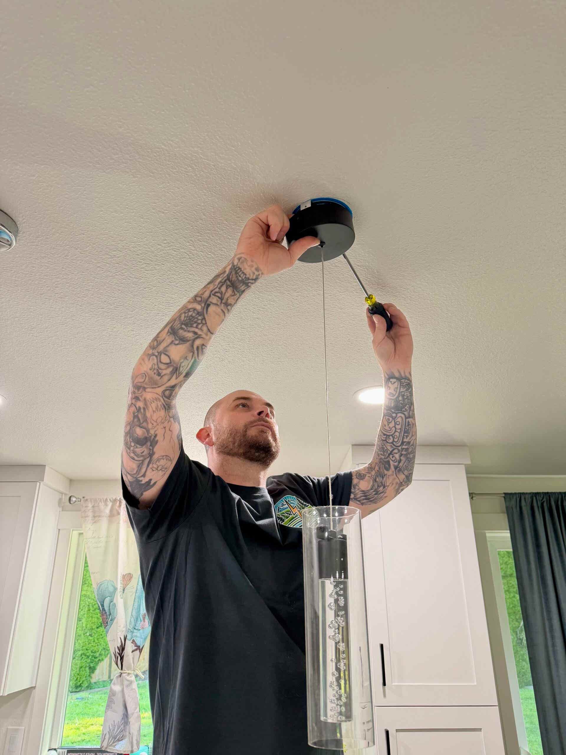 oak-harbor-wa-electrician-lighting-installation-johnson-electrical-services Licensed electrician installing modern pendant lighting in a kitchen remodel in Oak Harbor, WA by Johnson Electrical Services.