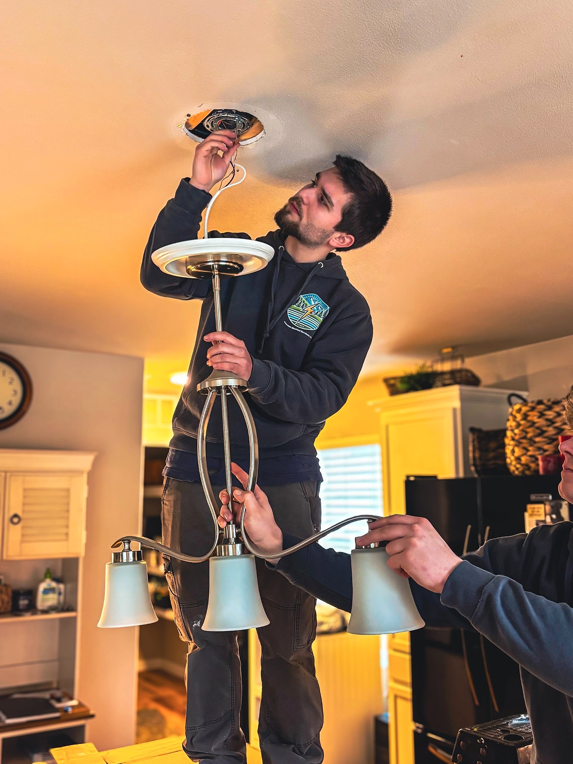 electrician-anacortes-wa-chandelier-light-fixture-installation Licensed electrician performing an electrical panel upgrade and wiring improvements in Anacortes, WA