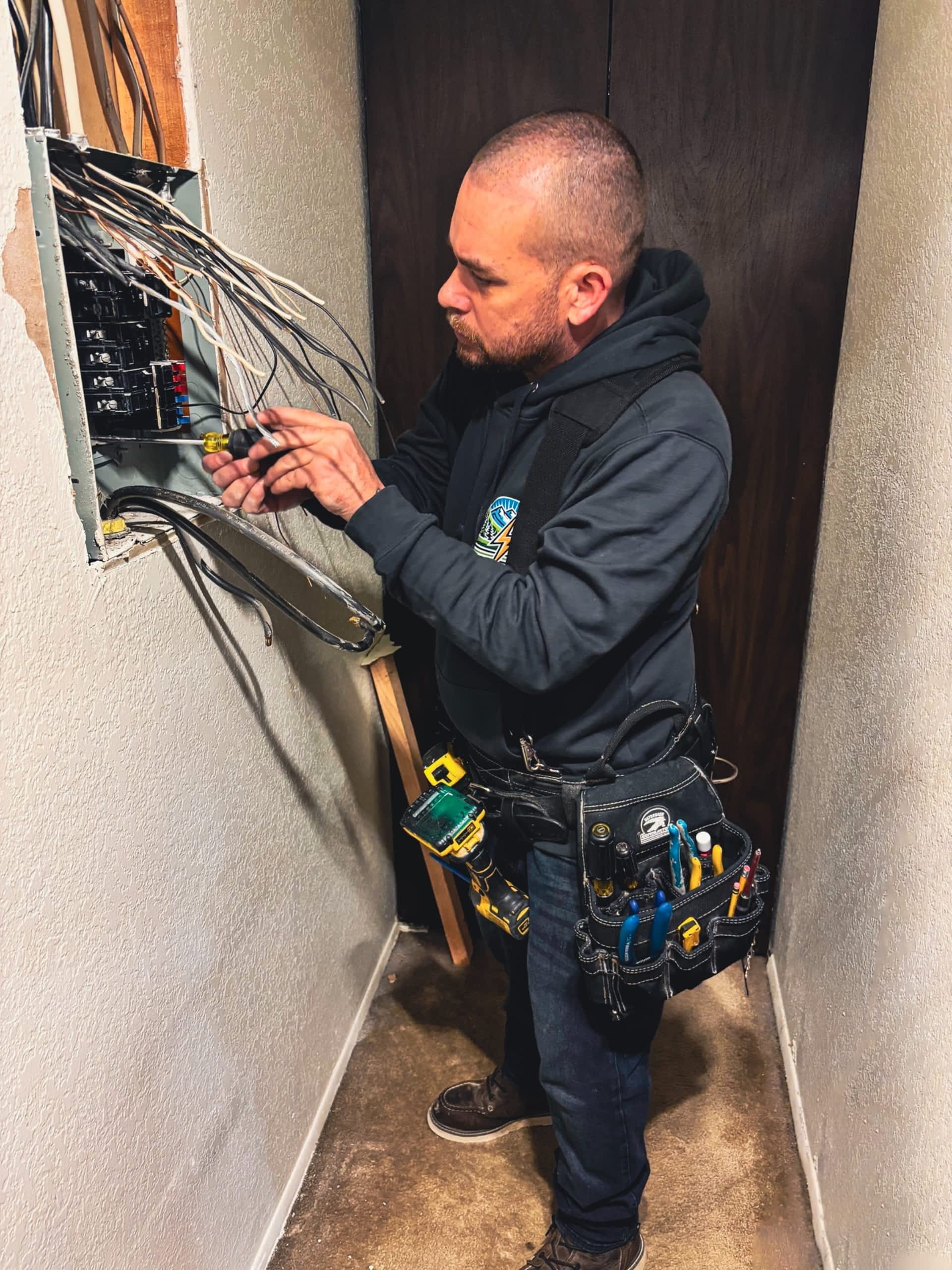 electrician-anacortes-wa-electrical-panel-upgrade Johnson Electrical Services electrician installing a modern dining room light fixture in Anacortes, WA