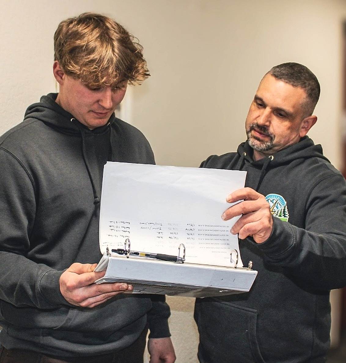 johnson-electrical-services-electrician-training-concrete-wa Johnson Electrical Services electrician reviewing project plans with an apprentice in Concrete, WA.
